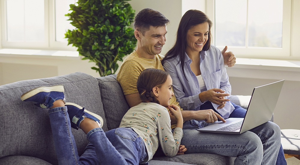 Happy family looking at their home inspection report on a laptop